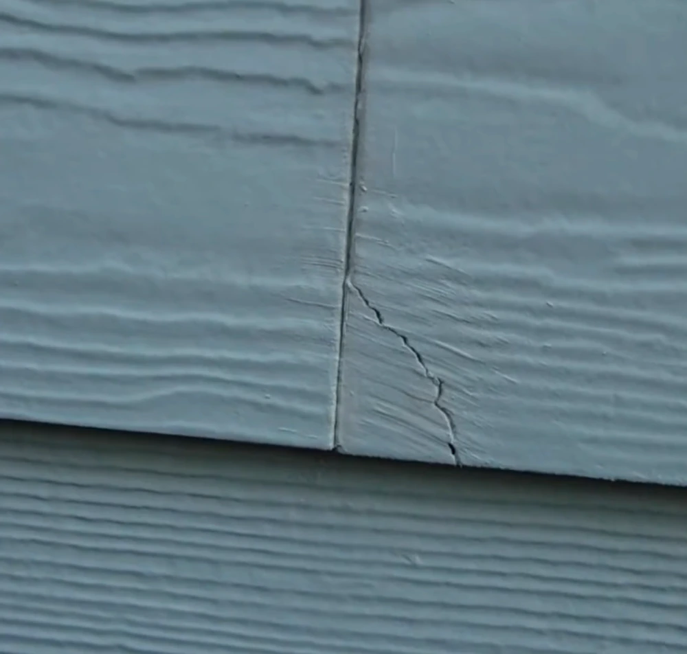 Damaged fiber cement siding board before repair