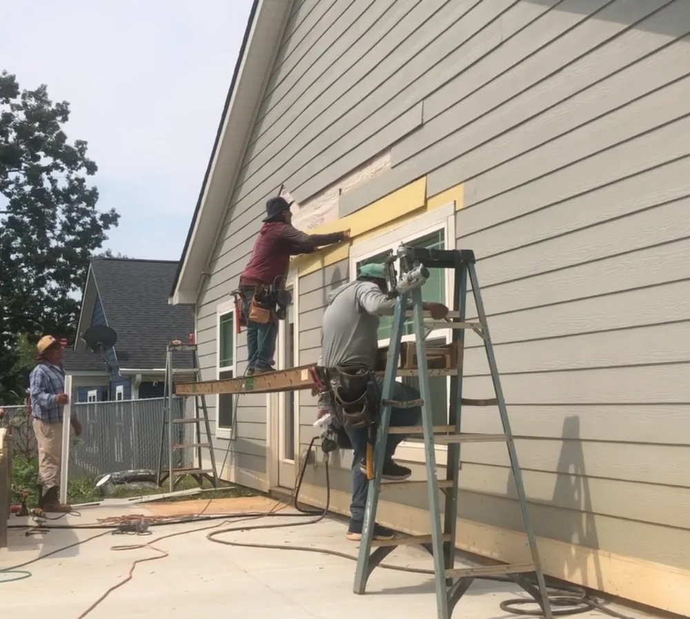 Team removing old siding during replacement